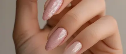 Primer plano de uñas en tonos rosados perlados con acabado brillante, resaltando un diseño minimalista y sofisticado.