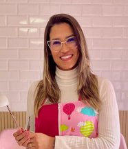 Profesional sonriente sosteniendo herramientas de trabajo en un ambiente cálido, con un fondo de azulejos blancos y detalles decorativos en tonos vivos.